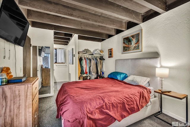 carpeted bedroom featuring beamed ceiling and a closet