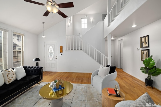 living room featuring light wood-type flooring, high vaulted ceiling, and ceiling fan