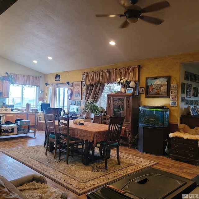 dining room with ceiling fan, wood-type flooring, and lofted ceiling