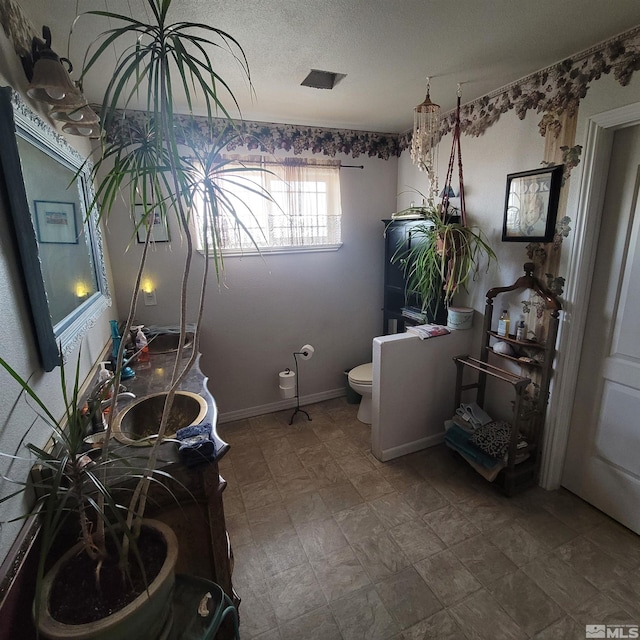 bathroom featuring toilet and a textured ceiling