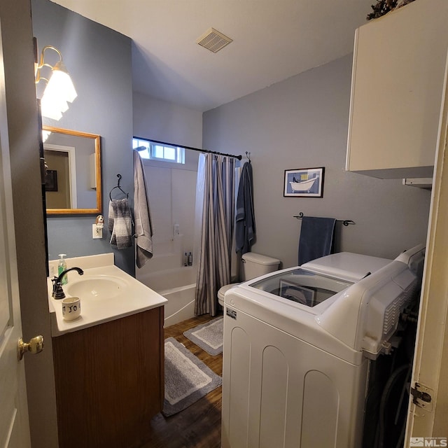 bathroom with vanity, independent washer and dryer, wood-type flooring, and shower / tub combo