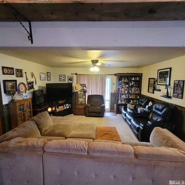 carpeted living room featuring beam ceiling and ceiling fan