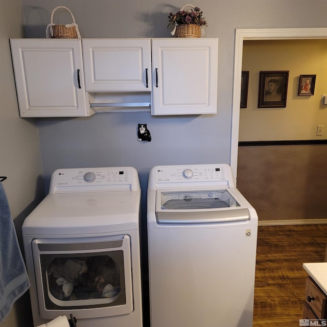 clothes washing area featuring cabinets, dark wood-type flooring, and washer and dryer