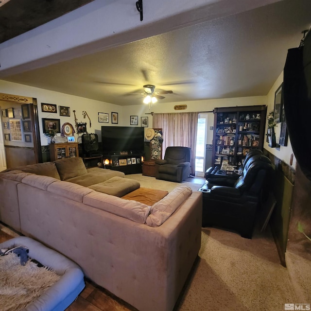 living room featuring ceiling fan and a textured ceiling