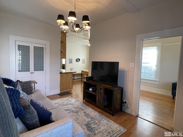 living room with hardwood / wood-style floors and ceiling fan with notable chandelier