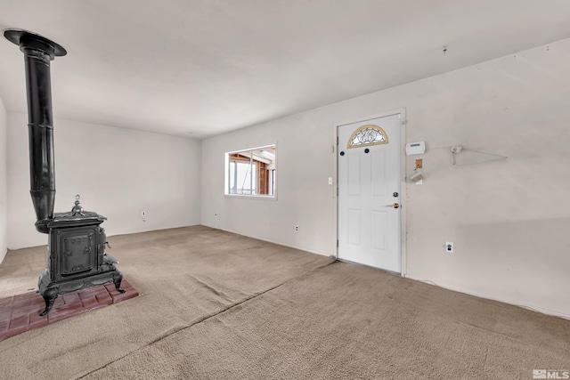 living room featuring carpet flooring and a wood stove