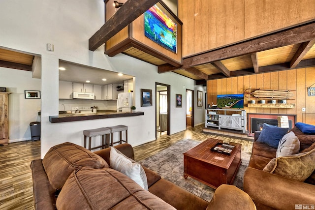 living room featuring wood ceiling, wooden walls, beamed ceiling, and dark wood-type flooring