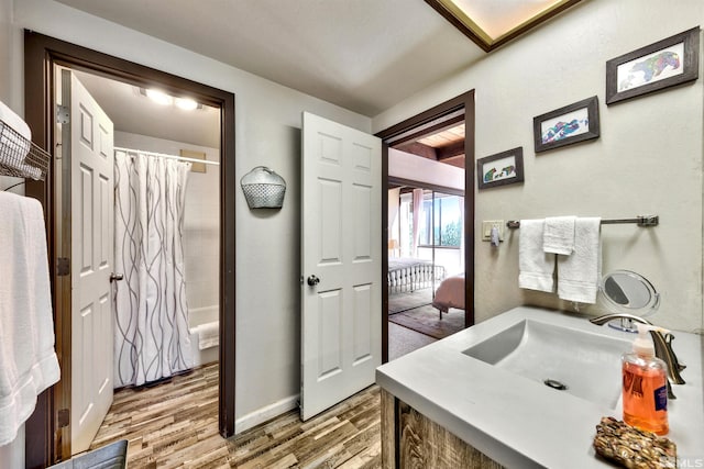 bathroom featuring hardwood / wood-style flooring, vanity, and shower / tub combo with curtain