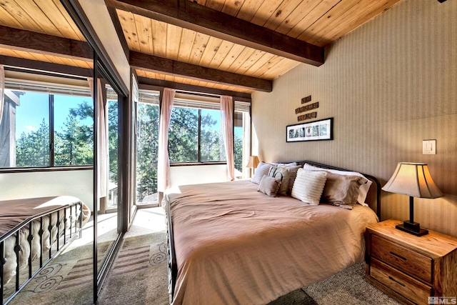 bedroom with carpet flooring, beam ceiling, multiple windows, and wood ceiling