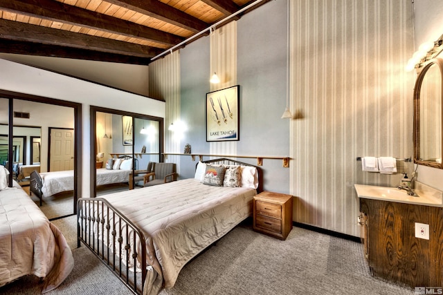 bedroom with carpet flooring, lofted ceiling with beams, and wood ceiling