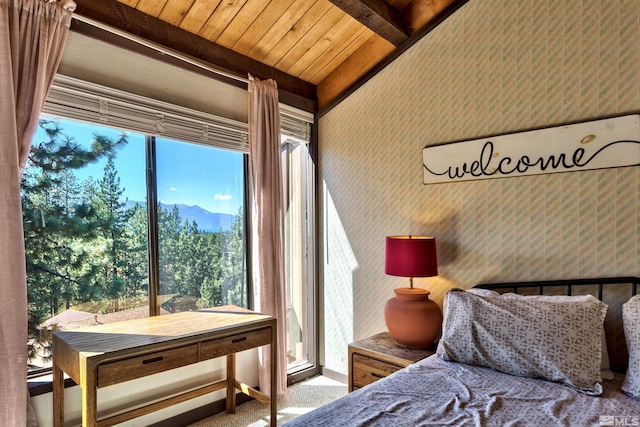 carpeted bedroom with beam ceiling, a mountain view, and wooden ceiling