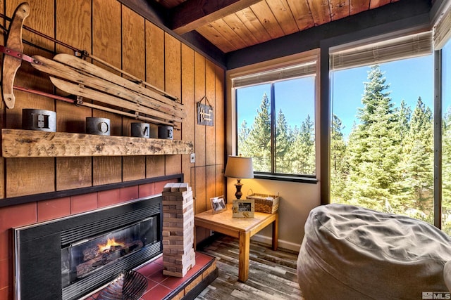 sunroom with beam ceiling, wood ceiling, and a tiled fireplace