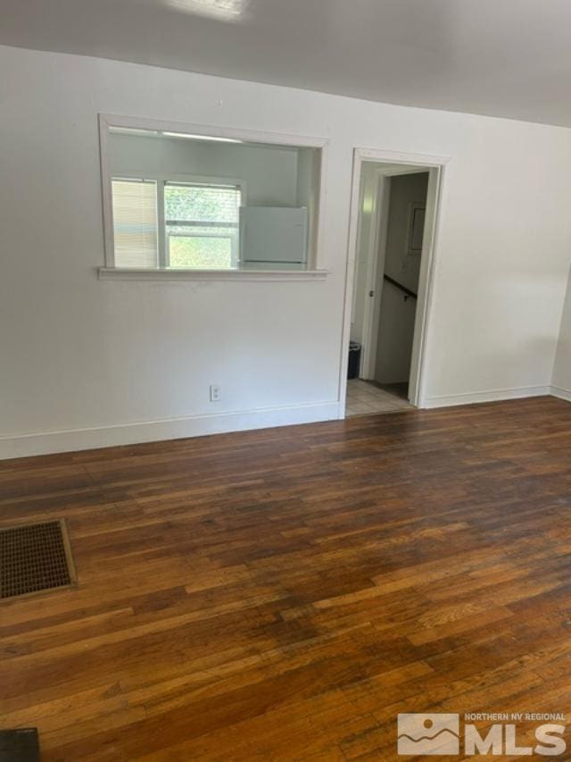 spare room featuring dark wood-type flooring