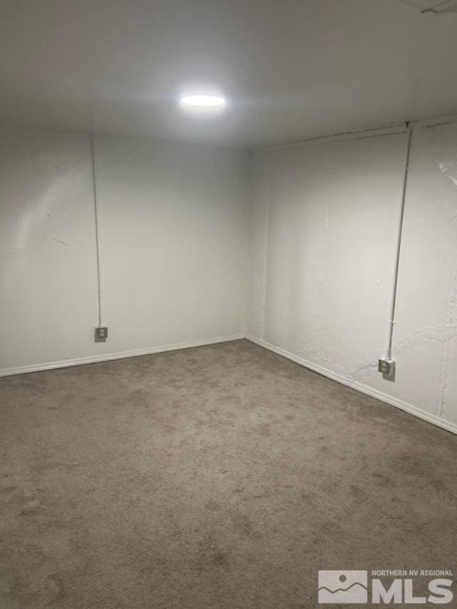 spare room featuring dark carpet