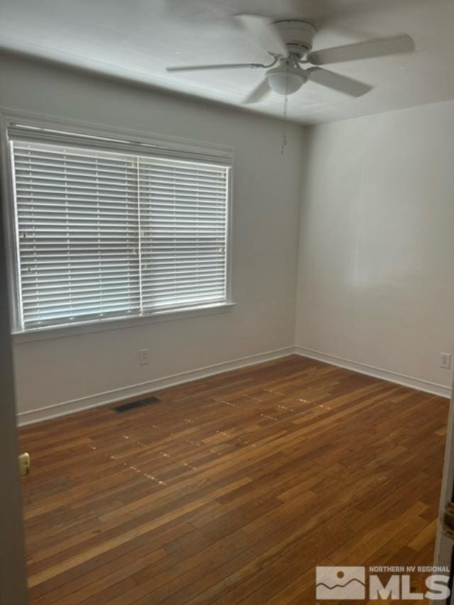 unfurnished room with ceiling fan and dark wood-type flooring