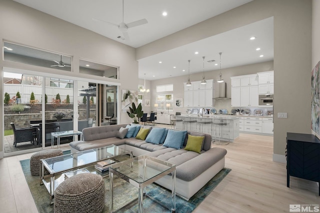 living room with ceiling fan and light wood-type flooring