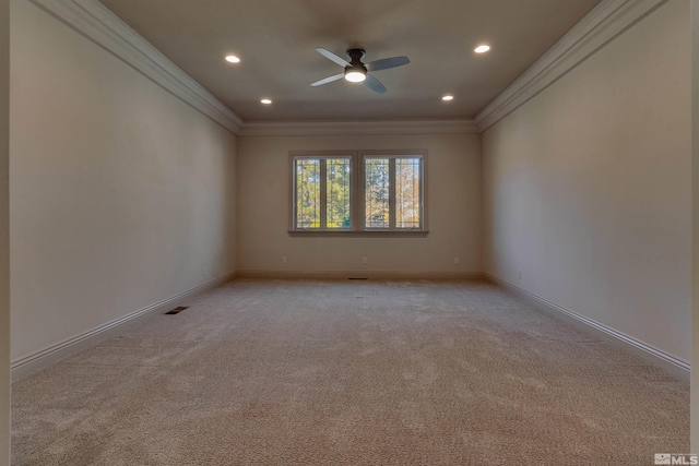 carpeted spare room featuring ceiling fan and crown molding