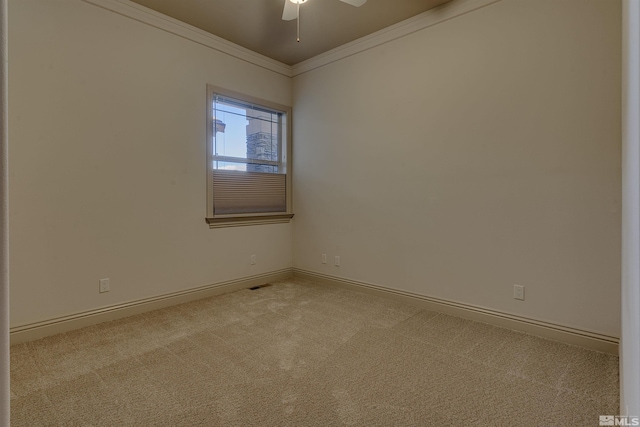 carpeted spare room with ceiling fan and crown molding