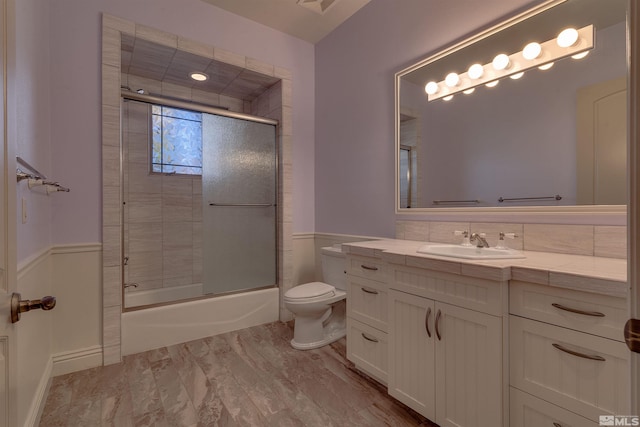 full bathroom with vanity, toilet, and enclosed tub / shower combo