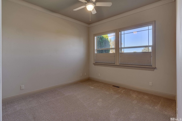 spare room with light carpet, ceiling fan, and crown molding