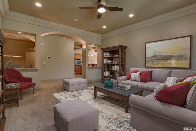 carpeted living room with ceiling fan and crown molding