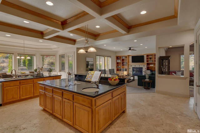 kitchen with a wealth of natural light, sink, an island with sink, and pendant lighting