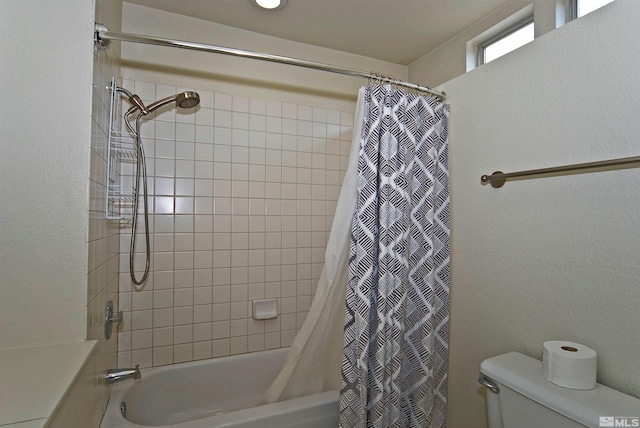 bathroom featuring shower / tub combo and toilet