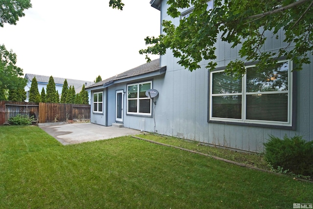 rear view of house with a yard and a patio area