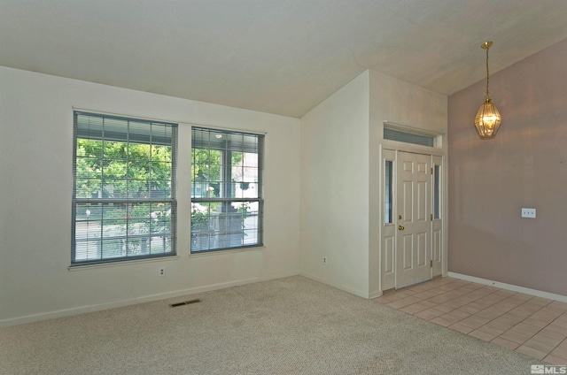 unfurnished room featuring light colored carpet and lofted ceiling