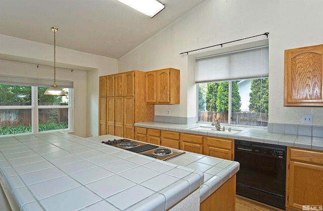 kitchen featuring tile countertops, a healthy amount of sunlight, sink, and black dishwasher