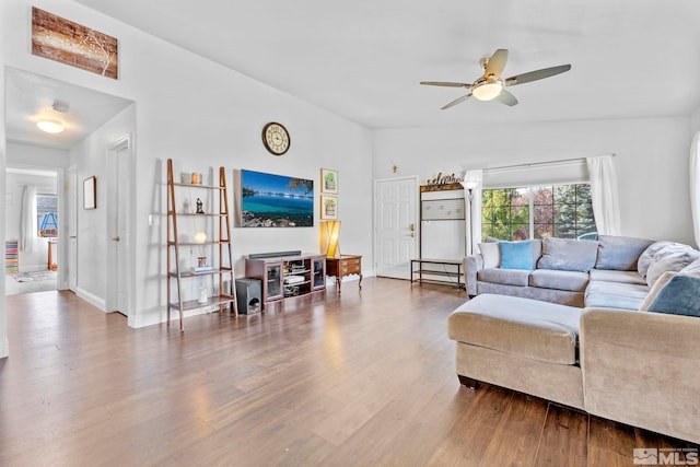 living room with wood-type flooring, vaulted ceiling, and ceiling fan