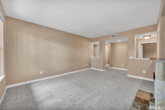 spare room featuring carpet floors, baseboards, and visible vents