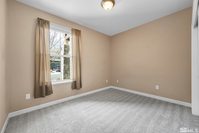 unfurnished room with carpet floors and baseboards