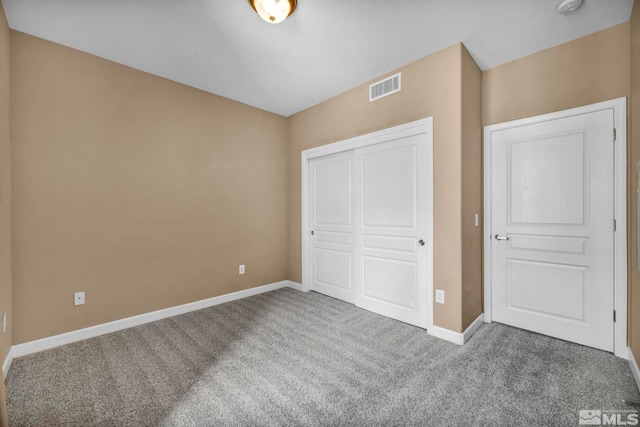 unfurnished bedroom featuring carpet floors, a closet, visible vents, and baseboards