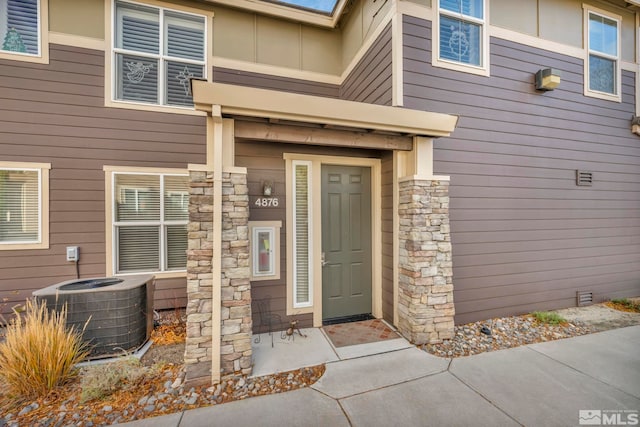 doorway to property with stone siding and central air condition unit