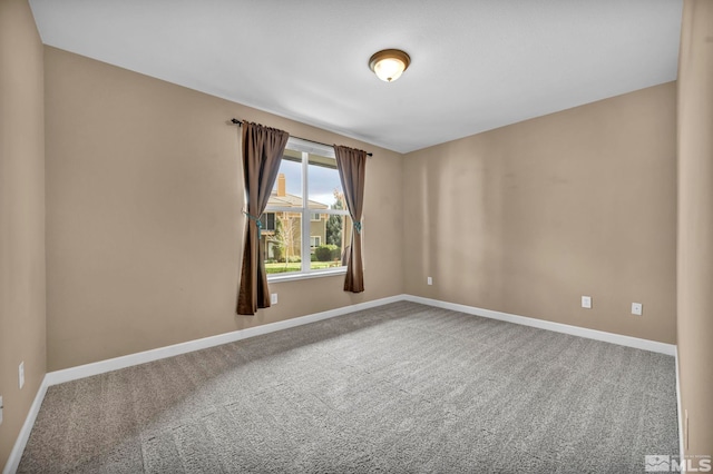 carpeted spare room featuring baseboards