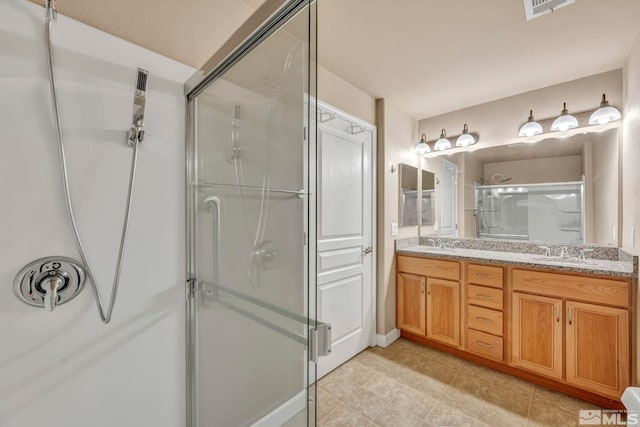 full bathroom featuring double vanity, a shower stall, visible vents, and a sink