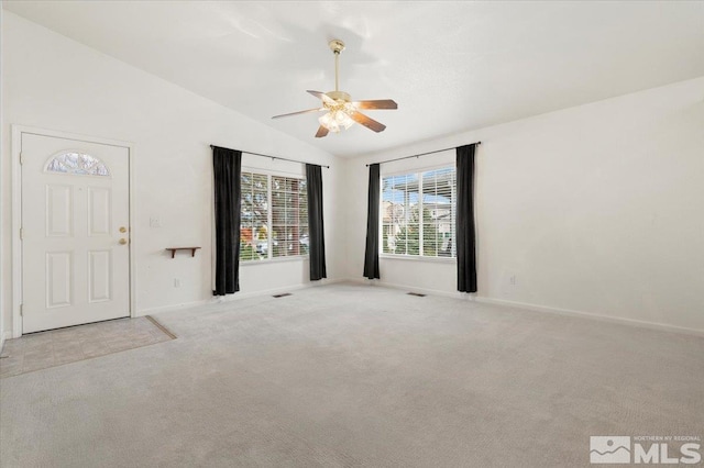 carpeted empty room with ceiling fan and vaulted ceiling