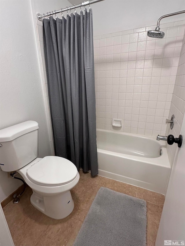 bathroom featuring tile patterned floors, toilet, and shower / bath combo with shower curtain