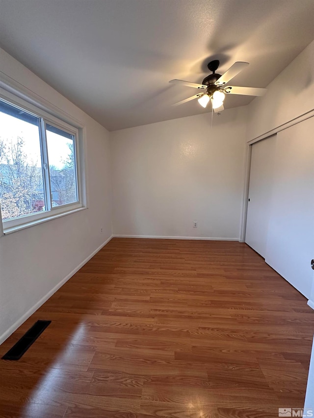 interior space with dark hardwood / wood-style floors, ceiling fan, and a closet