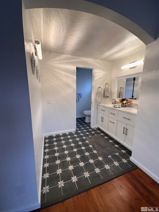 bathroom with hardwood / wood-style floors, vanity, and toilet