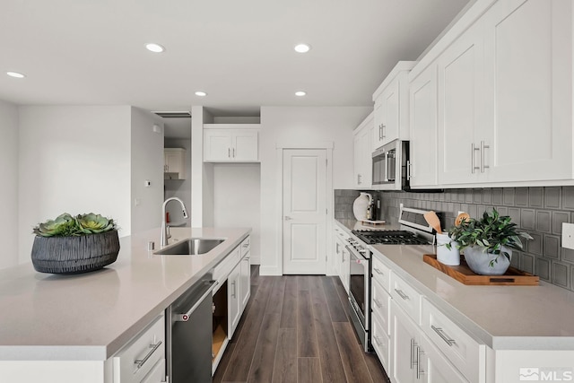 kitchen with sink, decorative backsplash, dark hardwood / wood-style flooring, white cabinetry, and stainless steel appliances