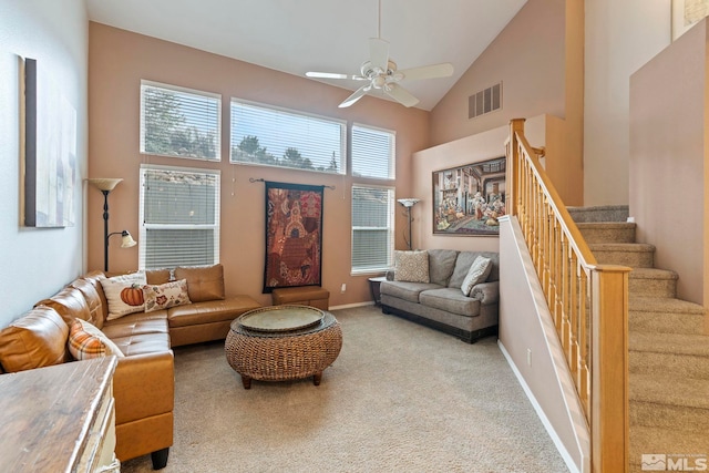 carpeted living room with high vaulted ceiling and ceiling fan