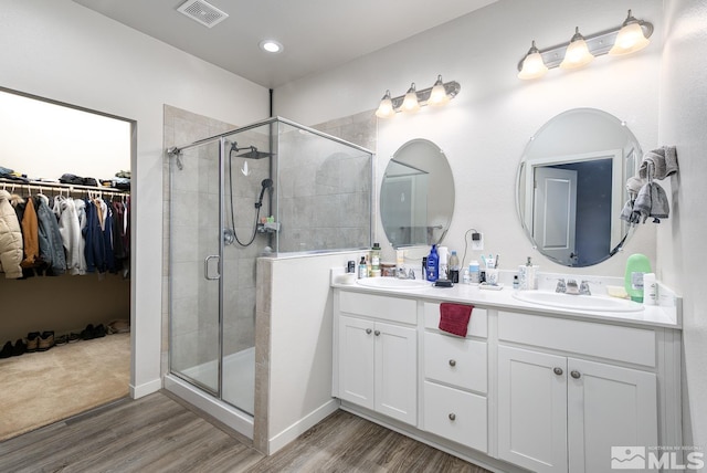 bathroom featuring vanity, hardwood / wood-style flooring, and a shower with door