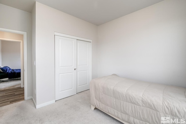 bedroom with light carpet and a closet