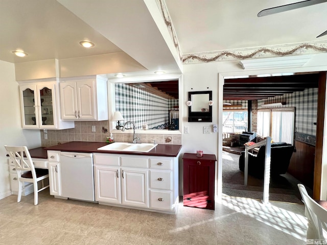 kitchen featuring tasteful backsplash, white dishwasher, sink, white cabinetry, and light tile patterned flooring