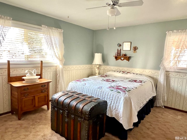 carpeted bedroom with multiple windows and ceiling fan