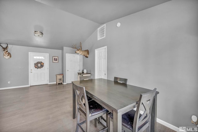 dining space with dark wood-type flooring and lofted ceiling