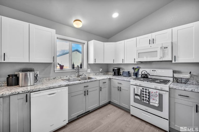 kitchen featuring lofted ceiling, white cabinetry, white appliances, and sink