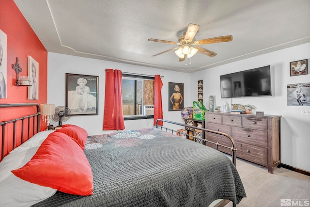 bedroom featuring ceiling fan, a textured ceiling, and light hardwood / wood-style flooring